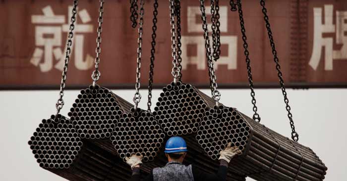 Trabalhador chinês ajuda no carregamento de hastes de aço