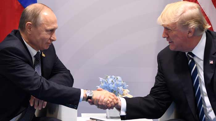 Vladimir Putin aperta a mão de Donald Trump 